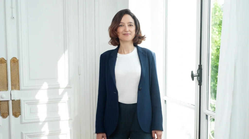 Maître Raphaële Secnazi-Leiba dans son bureau, posant devant une fenêtre, tenue sobre et professionnelle, lumière naturelle