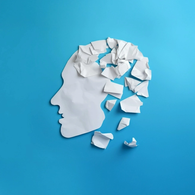 Silhouette de profil humain en papier déchiré représentant les séquelles d’un traumatisme crânien après un accident de la route