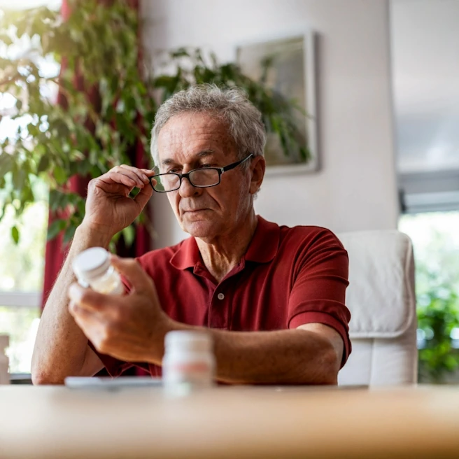 Patient lisant attentivement une prescription médicamenteuse afin de limiter les risques d’erreur médicale