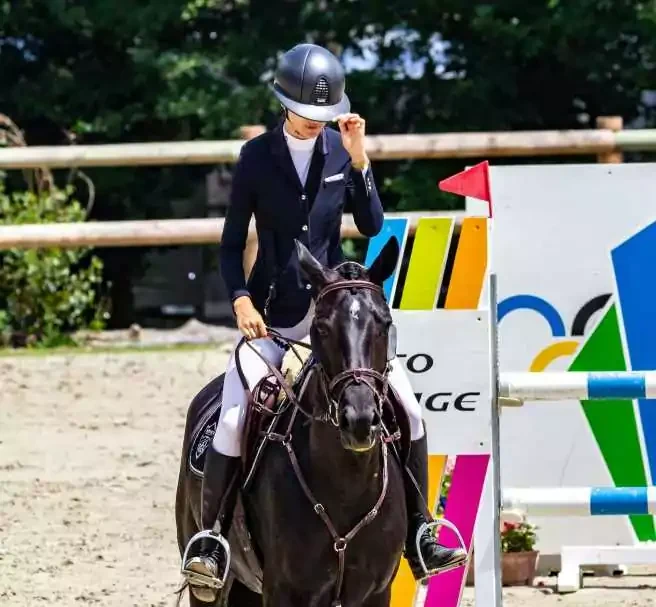 Cavalière à cheval sur un parcours d’équitation en centre équestre.