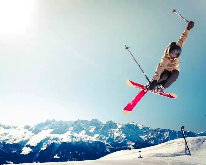 Skieur en saut sur une piste de montagne dans une station de ski