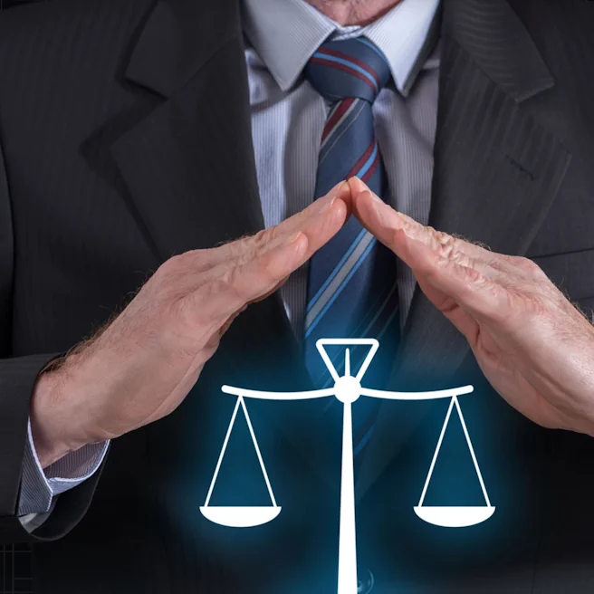 Illustration de la protection juridique avec balance de la justice sous les mains d’un homme en costume.