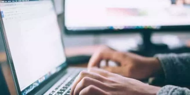 Mains utilisant un ordinateur portable pour envoyer une demande d’information.