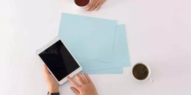 Table de travail avec tablette, documents et tasse de café