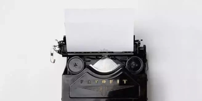 Machine à écrire avec une feuille blanche sur fond clair.